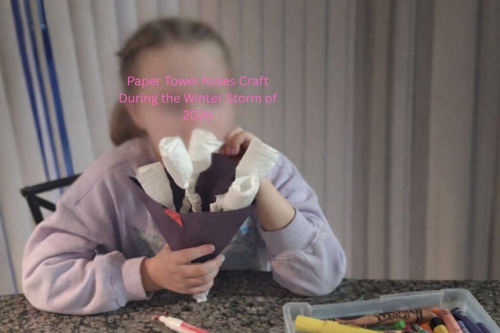 Child holding handmade paper towel roses during a family craft activity while sheltering at home during the 2026 winter storm (face intentionally blurred for privacy)
