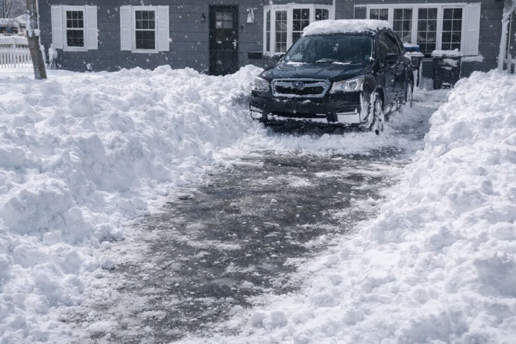 black subaru forester in driveway surrounded by deep snow after the 2026 winter storm