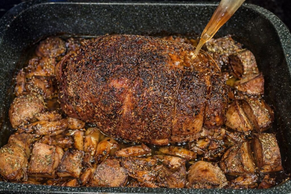 homemade porchetta roast with seasoned potatoes and carrots during winter storm preparation